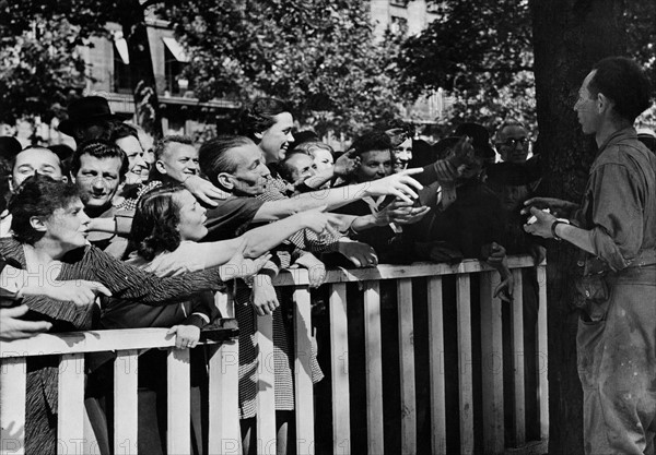 French soldiers hang out cigarettes and candy in Paris (France) August 25, 1944