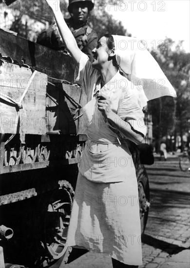 Nurse salutes French soldiers with flowers in Paris, August 25, 1944