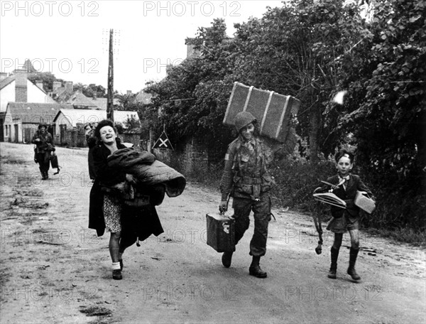 Un soldat américain aide une jeune femme, quelque part en Normandie  juin 1944