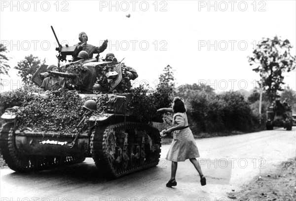 French girl pelts Yanks with flowers in St Pois, August 1944