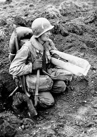 An American soldier  awaits his turn to cross the Roer river, February 23, 1945