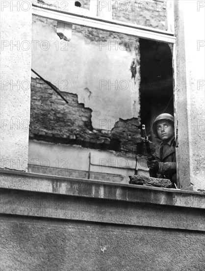 Soldat américain à l'affût des tireurs isolés à Aachen, octobre 1944