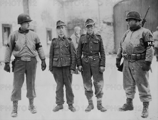 Près de Bastogne, des membres de la police militaires gardent des prisonniers nazis, janvier 1945