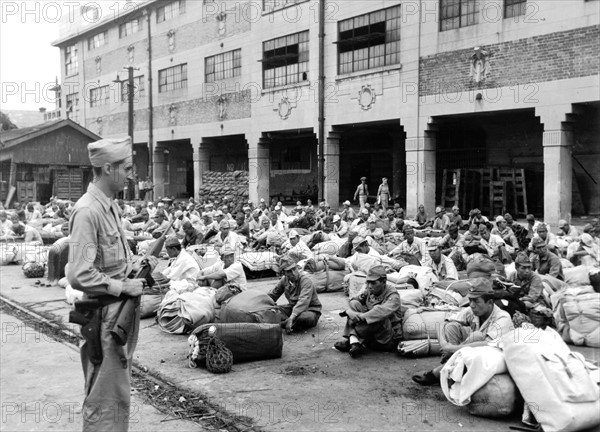 Japanese soldiers guarded by an American soldier at Shanghai, September 28, 1945