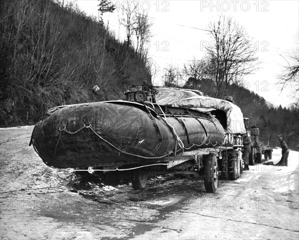 Des ingénieurs américains transportent les flotteurs d'un pont à jeter sur le fleuve Sauer, hiver 1944-45