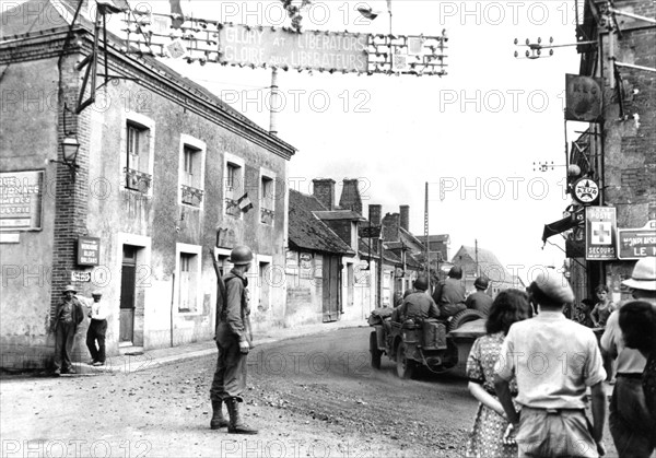 Les habitants d'un village français saluent les soldats américains en route vers Vendôme
(Août 1944)