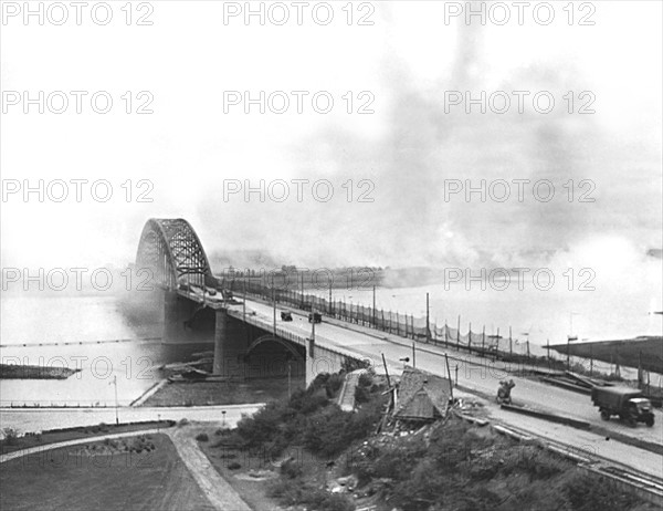 Allied Army trucks cross Nijmegen bridgge under fire  in Holland, September 20, 1944