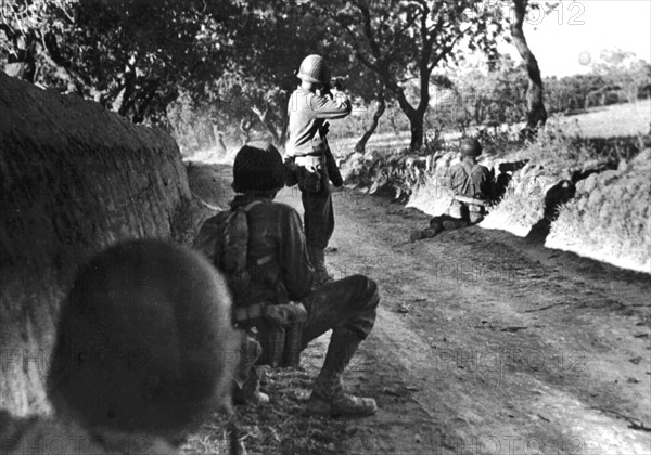 An American soldier fires at an enemy sniper on the outskirts of Canicatti, July 23, 1943