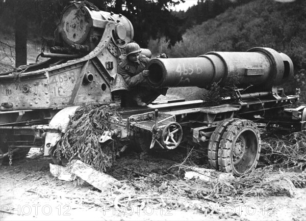 An American officer examines captured German gun near Wollseifen, 1945