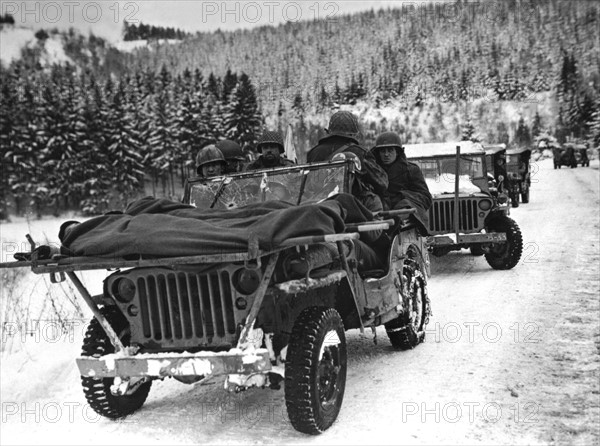 American medical men evacuate wounded in jeep in Belgium, January 1945