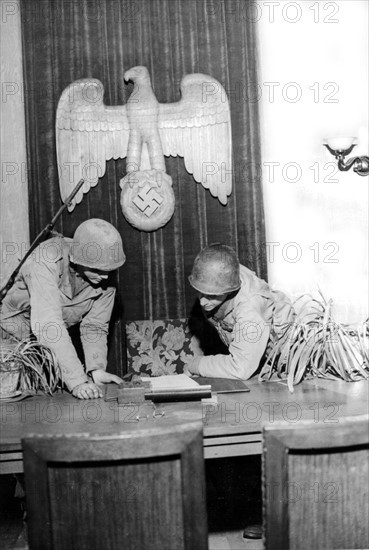 Soldats américains inspectant le bureau d'un dirigeant nazi à Hardt, en Allemagne. (1er mars 1945)