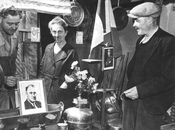 A Normandy  shopkeeper places a picture of President F.D. Roosevelt in his shop window in France (June 1944).