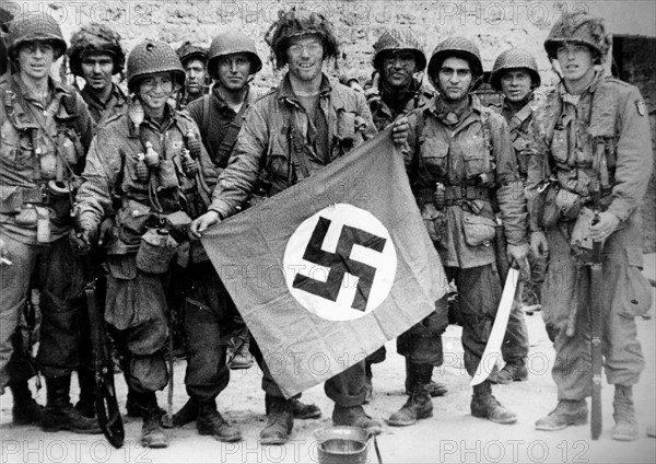 Un groupe de parachutistes américains exhibe un drapeau Nazi (juin 1944)