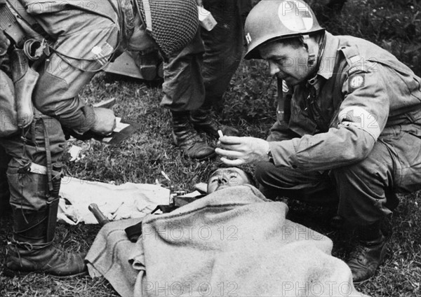 A medical officer and an injured German soldier (June 1944)