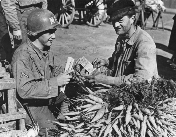 Sur le marché de Cherbourg, un soldat américain achète des légumes à un paysan normand