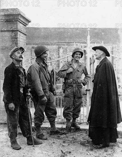 Two American soldiers fraternizing with the bishop of Nucilly, Normandy, France