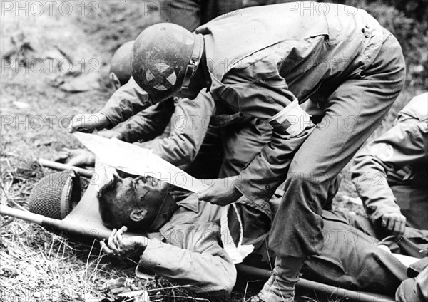 Un GI's blessé par un éclat de mortier allemand est soigné par un infirmier (1944)
