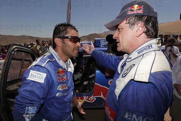 VW Race Touareg-Pilot Nasser Al-Attiyah (l) aus Katar und sein Teamkollege Carlos Sainz aus Spanien unterhalten sich am Montag (10.01.2011) nach der 8. Etappe der Rallye Dakar von Antofagasta nach Copiapo, Chile. Foto: Volkswagen/DPPI (ACHTUNG: Handout - Nur zur redaktionellen Verwendung und bei Nennung der Quelle: Volkswagen/DPPI )