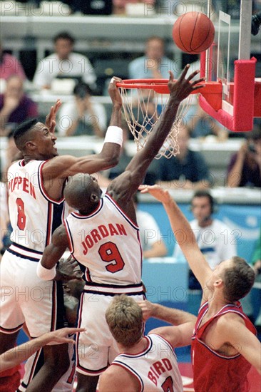 Die US-amerikanischen Basketballspieler Scottie Pippen (l) und Michael "Air" Jordan (Nr. 9) versuchen am 08.08.1992 bei den Olympischen Sommerspielen von Barcelona in der Begegnung USA - Kroatien den Flug des Balls in unmittelbarer Korbnähe positiv zu beeinflussen. Ihr Team-Kamerad Larry Bird (vorn, Nr. 7) beobachtet die Szene. Das amerikanische "Dream-Team" entscheidet das Spiel klar mit 117 : 85 zu seinen Gunsten und holt sich die Goldmedaille.