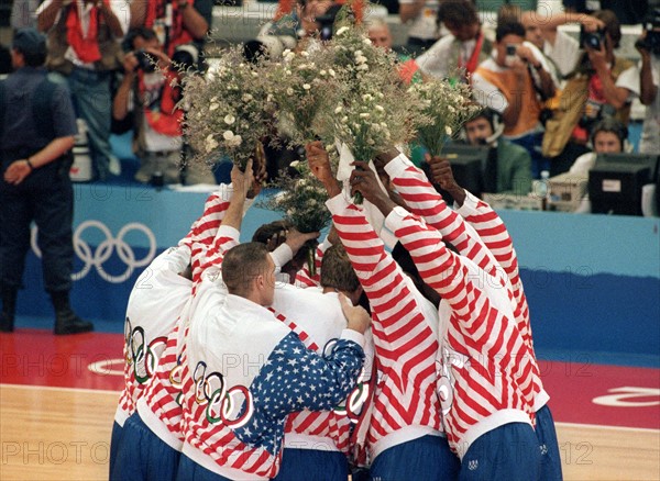 Die Mitglieder des legendären US-amerikanischen " Dream Teams " bilden am 08.08.1992 bei den Olympischen Sommerspielen von Barcelona bei der Basketball-Siegerehrung vor lauter Freude ein schier unentwirrbares Knäuel und halten dabei aber die überreichten Blumensträuße sorgsam in die Höhe. Die Amerikaner haben das Spiel gegen Kroatien mit 117 : 85 klar für sich entschieden und sich die Goldmedaille geholt.