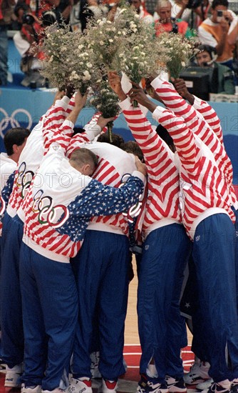 Die Mitglieder des legendären US-amerikanischen " Dream Teams " bilden am 08.08.1992 bei den Olympischen Sommerspielen von Barcelona bei der Basketball-Siegerehrung vor lauter Freude ein schier unentwirrbares Knäuel und halten dabei aber die überreichten Blumensträuße sorgsam in die Höhe. Die Amerikaner haben das Spiel gegen Kroatien mit 117 : 85 klar für sich entschieden und sich die Goldmedaille geholt.