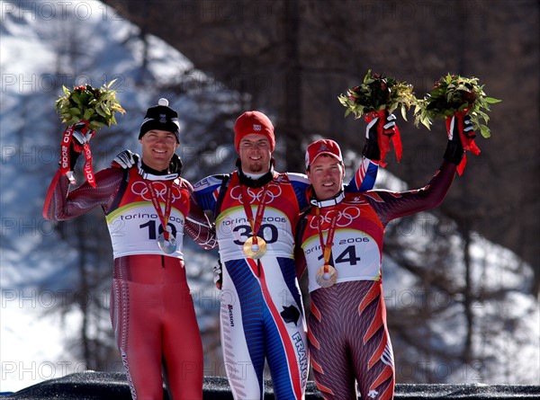 Der französische alpine Skifahrer Antoine Deneriaz (Mitte) gewinnt am 12.02.2006 die Goldmedaille bei der Abfahrt vor dem Österreicher Michael Walchhofer (l) und dem Schweizer Bruno Kernen (l) in Sestriere Borgata, Italien. Foto: Hiro Yakushi +++(c) Picture-Alliance / ASA+++