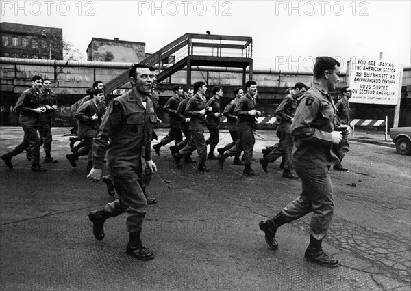 US soldiers jogging in front of the Berlin Wall