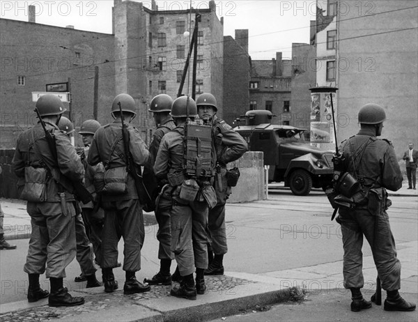 US soldiers in front of water cannon of People's Police at border crossing point Friedrichstrasse in Berlin 1961