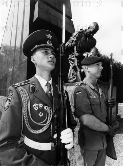 German and Russian soldier in front of Soviet monument in Berlin