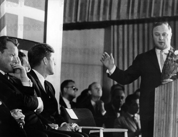 Leber hands over a bunch of carnations to Kennedy