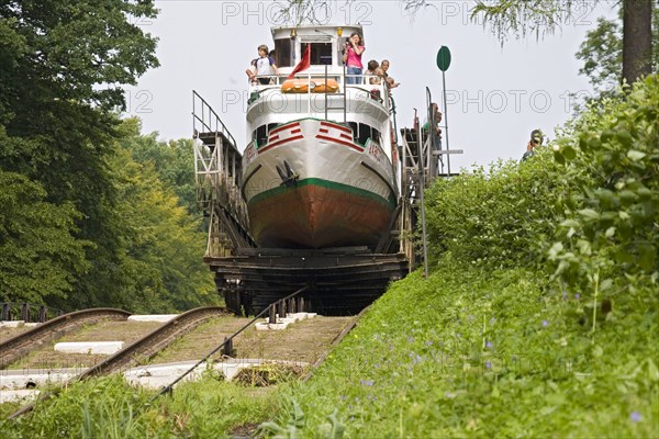 Touristenschiff wird am Oberlaenden Kanal mittels Wasserkraft auf einem Schienenwagen ueber die geneigte Ebene transportiert, tourist ship at the Elblag Canal being transported over the inclined plane on a rail carriage run only by water power