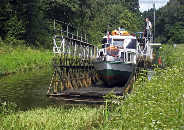 Schiff wird ueber Land gezogen auf dem Oberlandkanal in Polen, ship carried on land