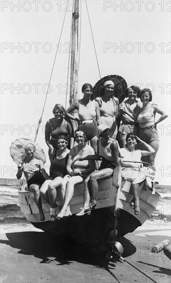 Eine Badegesellschaft von Frauen und Mädchen in Badekleidung posiert am Strand der Ostsee auf einem Holzboot mit dem Namen Möwe, aufgenommen  um 1928. Schon vor der Jahrhundertwende setzte der Bade-Tourismus an der Ostseeküste ein. Foto: Sammlung Sauer +++(c) dpa - Report+++ | Verwendung weltweit