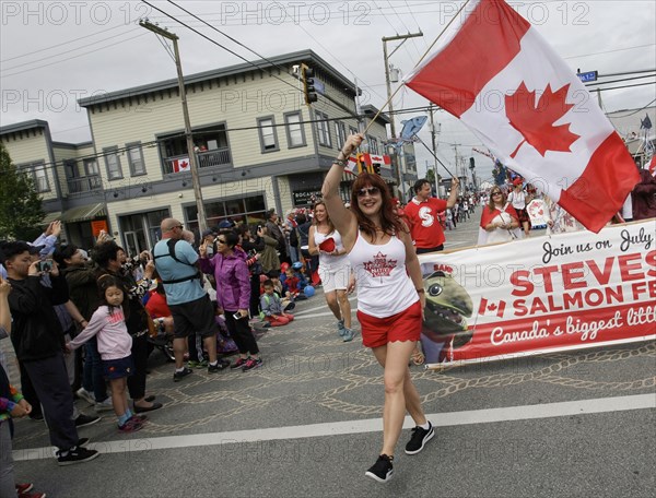 (180701) -- RICHMOND, July 1, 2018 () -- A woman waves the national flag of Canada during the 73rd Salmon Festival Parade in Richmond, Canada, July 1, 2018. Thousands of people participated in the 73rd Salmon Festival Parade in Richmond on Sunday to celebrate the Canada Day. (/Liang Sen) |