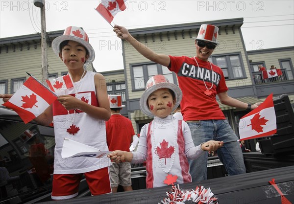 (180701) -- RICHMOND, July 1, 2018 () -- Local residents wave the national flag of Canada during the 73rd Salmon Festival Parade in Richmond, Canada, July 1, 2018. Thousands of people participated in the 73rd Salmon Festival Parade in Richmond on Sunday to celebrate the Canada Day. (/Liang Sen) |