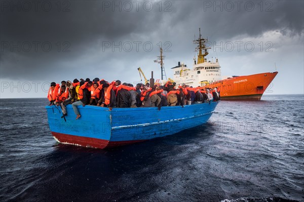 Etwa 380 Flüchtlinge in einem Holzboot und 130 Flüchtline in einem Gummiboot werden am 11.12.2016 in internationalem Gewässer vor der libyschen Küste im Mittelmeer von einem Search and Rescue Team der NGO SOS Mediterranee gerettet und auf der MS Aquarius nach Sizilien gebracht. An Bord der MS Aquarius werden die Flüchtlinge von den NGOs SOS Mediterranee und Ärzte ohne Grenzen versorgt. | Verwendung weltweit