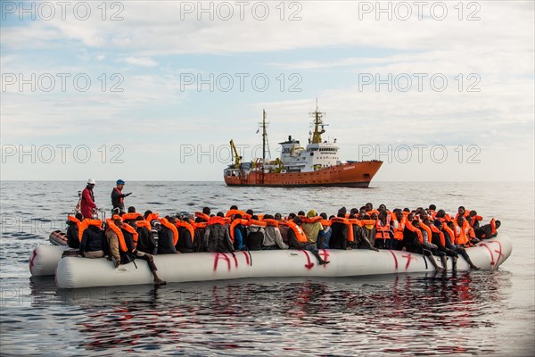 Etwa 130 Flüchtlinge werden am 11.12.2016 in internationalem Gewässer vor der libyschen Küste im Mittelmeer aus einem Gummiboot von einem Search and Rescue Team der NGO SOS Mediterranee gerettet und auf der MS Aquarius nach Sizilien gebracht. An Bord der MS Aquarius werden die Flüchtlinge von den NGOs SOS Mediterranee und Ärzte ohne Grenzen versorgt. | Verwendung weltweit