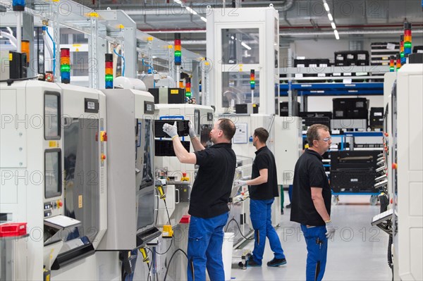 Ouvriers au travail dans l'usine de batteries pour voitures électriques Deutsche ACCUmotive de Kamenz, en Allemagne, le 22 mai 2017. Le même jour, la première pierre d'une nouvelle usine de batteries Accumotive a été posée.