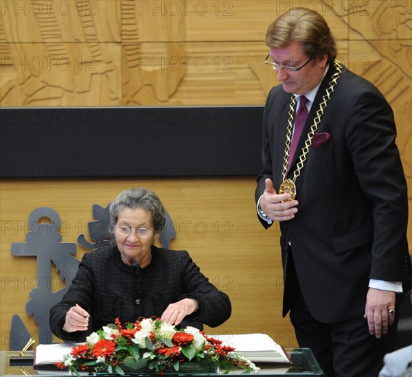 French politician Simone Veil (L) signs in a book after being awarded with the Heinrich Heine Prize, as Dirk Elbers, first mayor of Duesseldorf, looks on in Duesseldorf, Germany, 13 December 2010. Veil received the prize that carries a value of