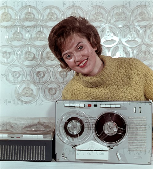 Eine Frau präsentiert das RFT Bandgerät BG 26-1, aufgenommen um 1963.