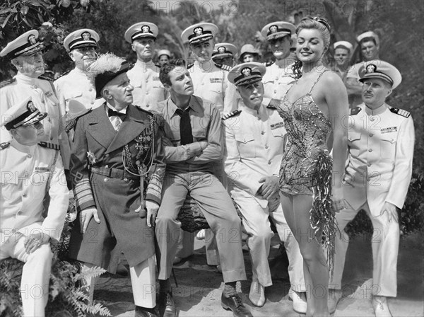 Auf einer Insel mit dir (On An Island With You, USA 1948, Regie: Richard Thorpe) Peter Lawford (mi. sitzend), Esther Williams, Jimmy Durante (historische Uniform mit Orden) / junge Frau in Badenanzug, Badekleidung, sexy, erotisch, im Mittelpunkt, umschwärmt, alte Herren, US-Offiziere un Uniform, Veteranen; Revuefilm, Musikfilm / WICHTIG: Nutzung nur redaktionell bei Berichterstattung über diesen Film. Titel-, Buch- und Kalendernutzungen nur nach Absprache. IMPORTANT: To be used solely for editorial coverage of this specific motion picture RESTRICTIONS: No cover, book or calendar use / rmr2 || Mininum fee EUR 5