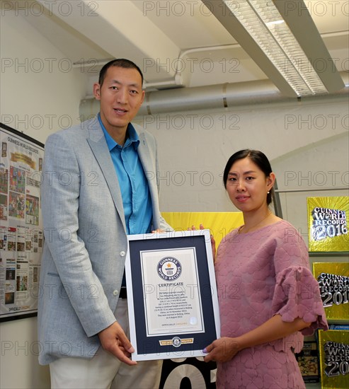 Sept. 10, 2015 () -- China's Sun Mingming and his wife Xu Yan pose for a photo during their visit at the Guinness World Records headquarters in London, Britain, on Sept. 10, 2015. With a combined height of 423.47cm, Sun Mingming and his wife Xu Yan claim the title for the world's tallest married couple.