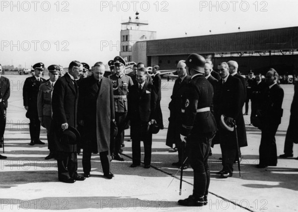 British Premier Neville Chamberlain returns to London after the second meeting with Hitler in Godesberg from 22 to 24 September 1938 to settle the Sudeten Crisis. The Nazi Propaganda! on the back of the image reads: "Chamberlain returns to London. On Saturday, he said goodbye to Reich Minister for Foreign Affairs Ribbentrop at Cologne Airport. Our image shows: Chamberlain and Ribbentrop talking. (l-r) General Consul Bell in Cologne, and Ambassador von Dirksen." Photo: Fotoarchiv für Zeitgeschichte/Archiv || Mininum fee EUR 40