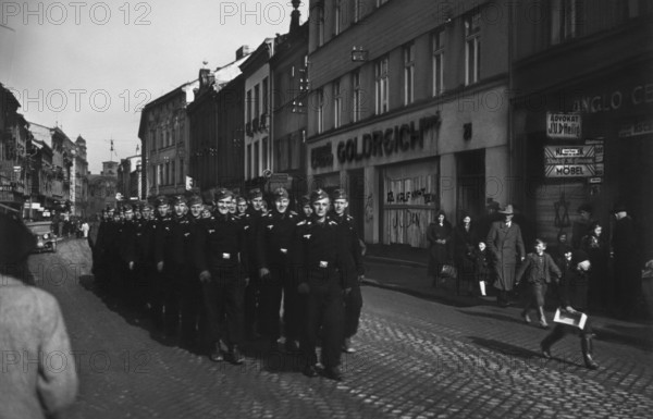Aufmarsch von Soldaten der deutschen Wehrmacht im besetzten Jihlava/Tschechien , antisemitische Schmierereien an Schaufenster von jüdischem Geschäft ("Goldreich") / Mähren, Sudeten, Iglau, marschieren, Soldatenfoto, Besetzung Tschechiens durch das Deutsche Reich, Zweiter Weltkrieg, world war II, 2, two, 2. WK, WK2; Nationalsozialismus, Drittes, Dritte Reich, third, NS-Regime, Faschismus, Antisemitismus / Firmenschild: "Rudolf Hoffmann Möbel", Schaufensterschmiererei "Kauf nicht beim Juden", Schild: Advokat / Anwalt J.U. Dr. Heilig / RTG13