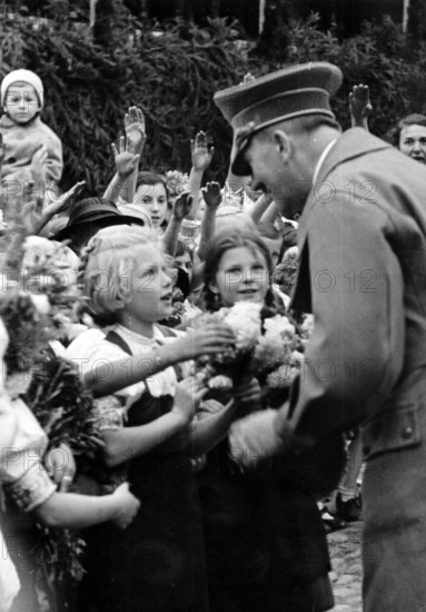 The image from the Nazi Propaganda! shows Adolf Hitler as he is greeted enthusiastically by the population during his visit of the city Eger (today: Cheb in the Czech Republic) on 3 October 1938 - here girls give him flowers. A day after the signing of the Munich Agreement, German troops occupied Eger on 1 October 1938. Photo: Fotoarchiv für Zeitgeschichte/Archiv || Mininum fee EUR 40
