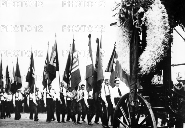 The Nazi propaganda photo shows the funeral procession for murdered supporter of the Sudetenland party (SdP), Alfred Knoll, in Jaegerndorf (Krnov), Sudetenland, September 1938. The original Nazi text on the back of the picture reads "Farewell to Alfred Knoll. He died under mysterious circumstances. On Sunday afternoon, tens of thousands of people took part in the funeral procession for SpD member Alfred Knoll. The official Czech report said that Knoll committed suicide after being locked up in a Czech prison. Alfred Knoll was known to be a fun-loving person. The doctor found Knoll's skull was smashed. - The flags of the Sudetenland German movement behind the funeral procession in the streets of Jaegerndorf." Photo: Fotoarchiv für Zeitgeschichte/Archive - NO WIRE SERVICE || Mininum fee EUR 40