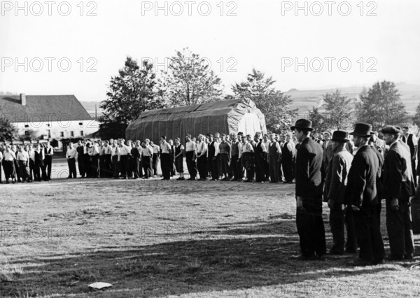 The Nazi propaganda picture shows men lining up for the Sudeten German Freikorps in September 1938. Hitler ordered the formation of the Freikorps at the height of the Sudetenland Crisis on 17 September 1938. The original text from a Nazi news report on the back of the picture reads: "The Sudeten German Freikorps assembles. Everywhere along the border there are registration stations, where capable Sudeten German refugees are registering for arms. In their faces, it can be seen that they recognize the seriousness. They are ready with weapons in hand to protect the homeland with their blood and possessions." Photo: Fotoarchiv für Zeitgeschichte/Archive - NO WIRE SERVICE || Mininum fee EUR 40
