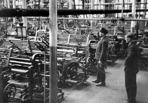 Das Motiv aus der nationalsozialistischen Propaganda zeigt Webstühle in der Weberei Geipel & Sohn in Asch (heute As in Tschechien), aufgenommen im Oktober 1938. Der Originaltext der nationalsozialistischen Berichterstattung auf der Rückseite des Bildes lautet: "Die fast stillgelegte Weberei Geipel & Sohn in Asch. Die Weberei Geipel & Sohn in Asch beschäftigte früher 2000 Arbeiter, heute nur noch 300 Arbeiter, von 1000 Webstühlen wurden 800 außer Betrieb gesetzt. Baldige Abhilfe wird nun hier geschaffen, in kurzer Zeit sollen alle Webstühle wieder in Betrieb gesetzt werden. Blick auf die stillgelegten Webstühle." Foto: Fotoarchiv für Zeitgeschichte/Archiv - KEINE BILDFUNKVERWENDUNG - || Mininum fee EUR 40