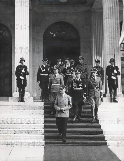 Adolf Hitler verläßt den sog. "Führerbau" in München nach der ersten Besprechung während der Münchner Konferenz am 29. September 1938. Hinter Hitler dessen Adjudant SS-Brigadeführer Julius Schaub, SS-Gruppenführer Karl Wolff, Chef des persönlichen Stabes Himmlers, Reichsleiter Martin Bormann und der Reichsführer-SS Heinrich Himmler.