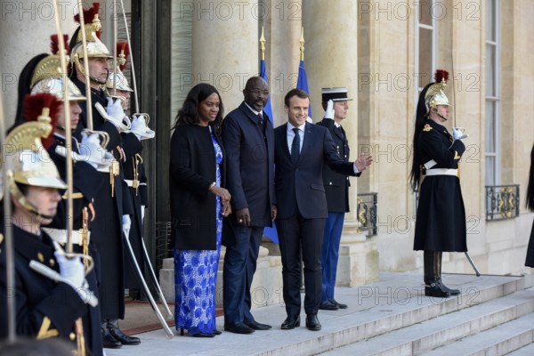 French President Emmanuel Macron and the newly elected visiting Leberian President George Weah pose for photos at Elysee Palace in Paris, France on Feb. 21, 2018.